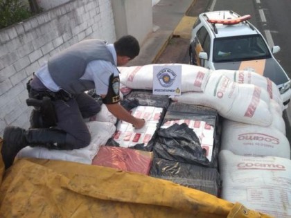 Caixas de cigarros estavam escondidas sob a carga de farinha de trigo no caminh�o que foi abordado em Iep� (Foto: Pol�cia Militar Rodovi�ria/Divulga��o)