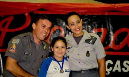 Instrutores do Proerd, Cabo PM Marcelo e SD Edilaine premiando uma de suas alunas (foto de Cristiano Nascimento)