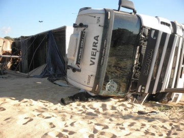 Caminh�o carregado com farelo de soja tomba no trevo de Parapu�